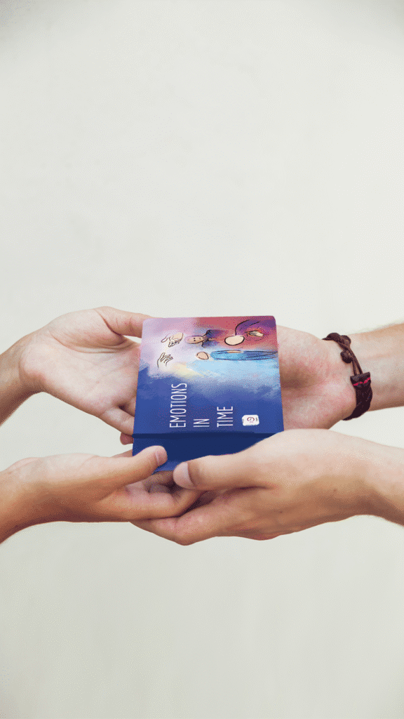 Hands exchanging a colorful therapy card titled Emotions in Time. A warm gesture of emotional support and self-reflection.