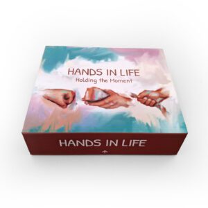 A box of Hands in Life: Holding the Moment therapy cards, illustrating shared connection and creative healing.