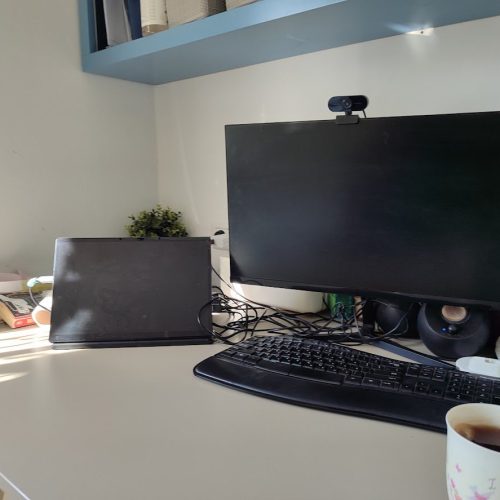 Cozy workspace with a computer, books for self-reflection, and a warm mug, creating a supportive spot for creative healing.